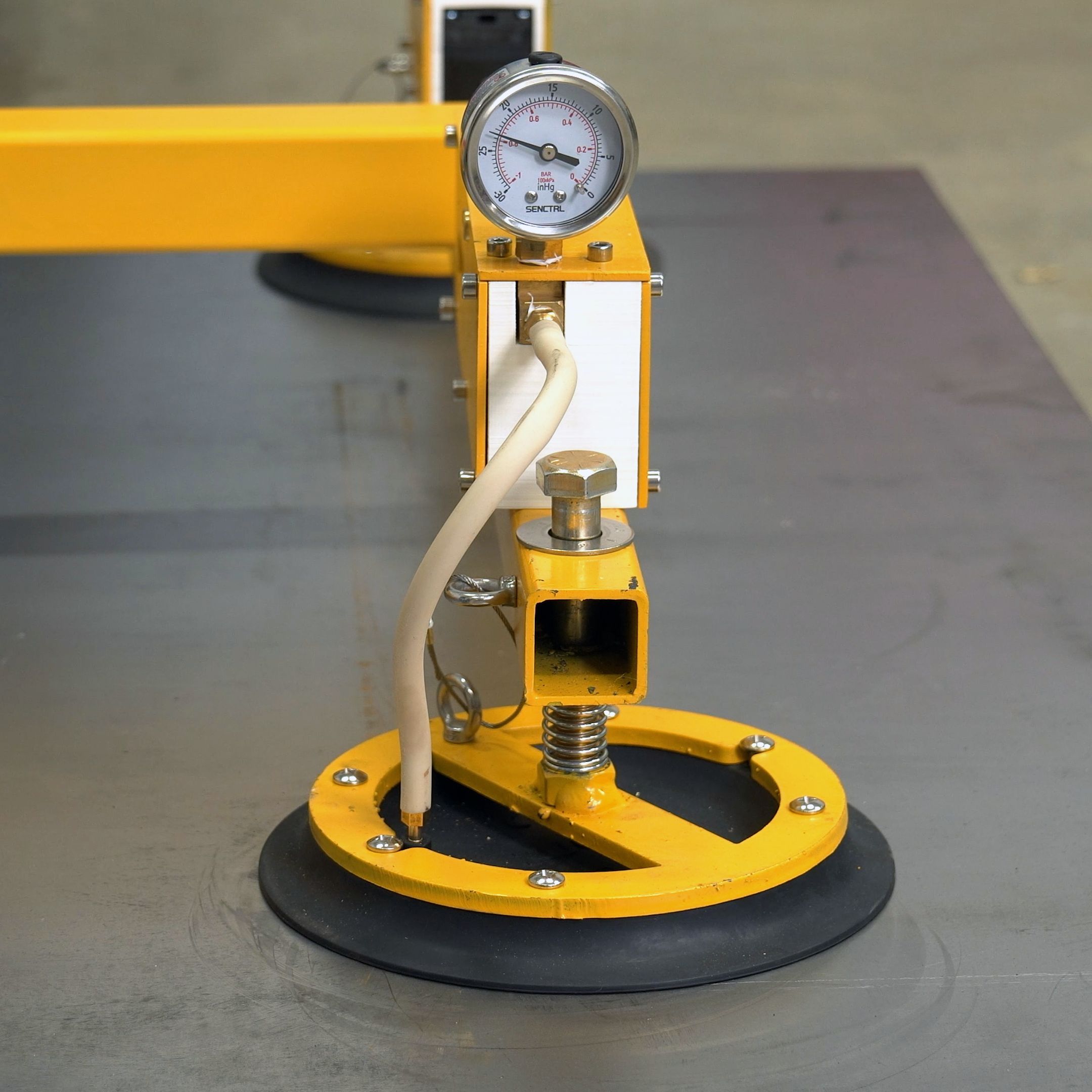 Vacuum lifter suction cup adhering to metal, which is confirmed by a vacuum gauge